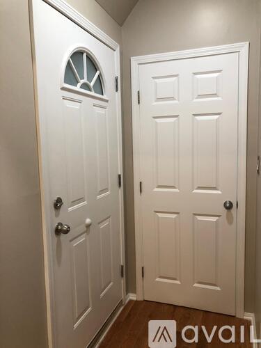 A white door with a window in the middle and a smaller white door on the right.