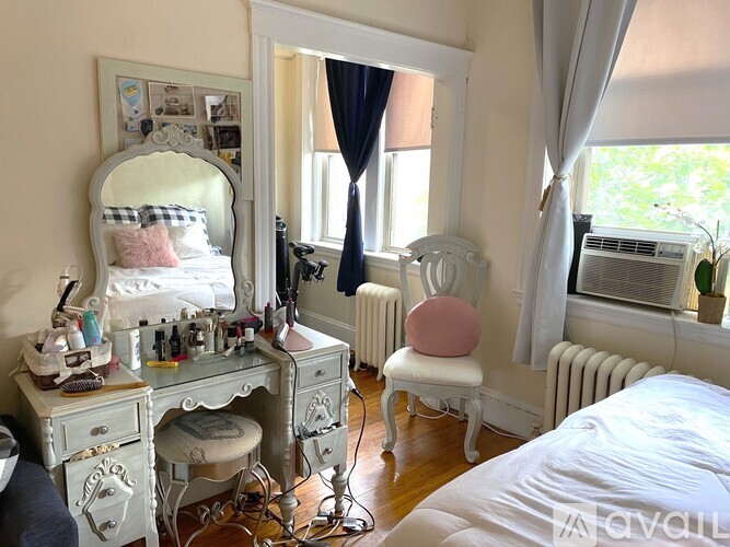 A vanity table with a mirror and a chair is in a room.