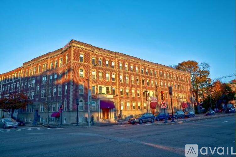 A large red brick building with a red awning sits on a street corner.
