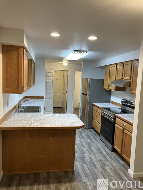 A kitchen with wooden cabinets and a marble countertop.