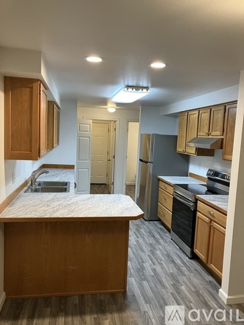 A kitchen with wooden cabinets and a marble countertop.