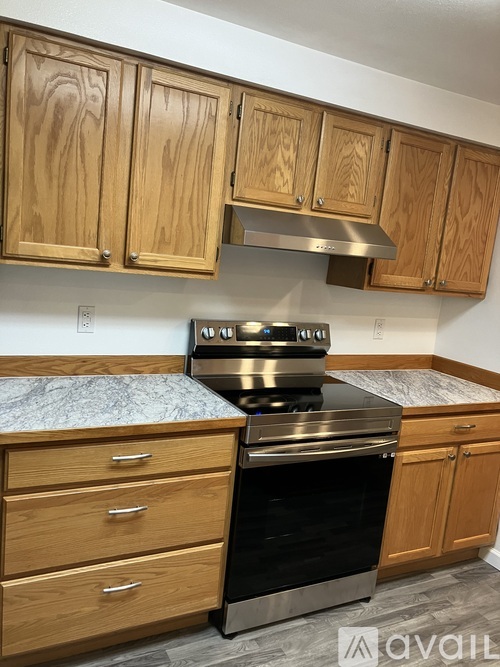A kitchen with wooden cabinets and a stove top oven.