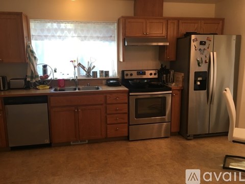 A kitchen with wooden cabinets and a stainless steel refrigerator.