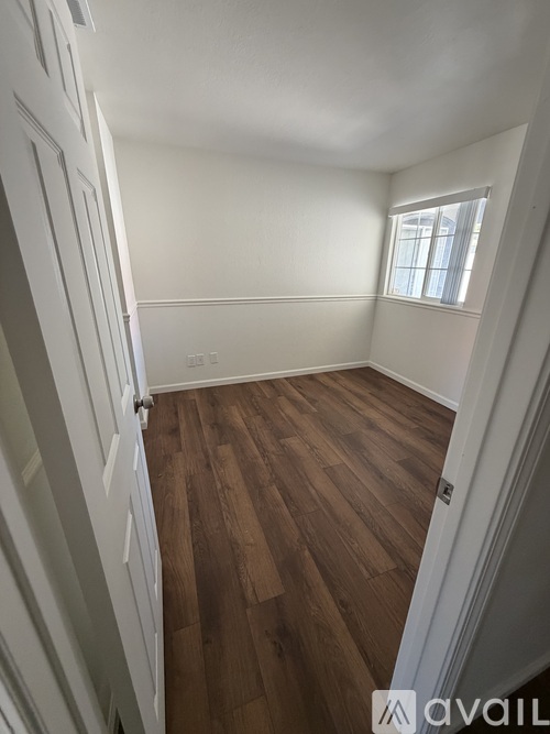 A room with wooden flooring and a window.
