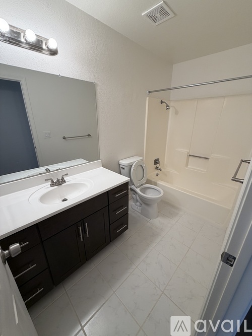 A bathroom with a sink, toilet, and bathtub.
