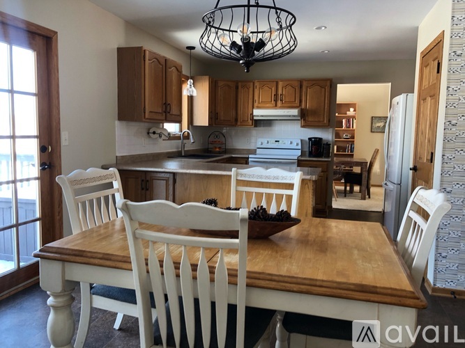 A kitchen with a table and chairs in front of it.