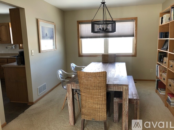 A dining room with a wooden table and chairs.