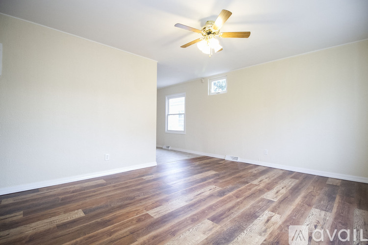 A room with wooden flooring and a ceiling fan.