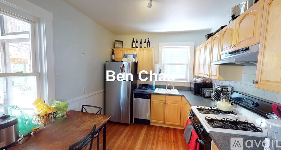 A kitchen with wooden cabinets and a stainless steel refrigerator.