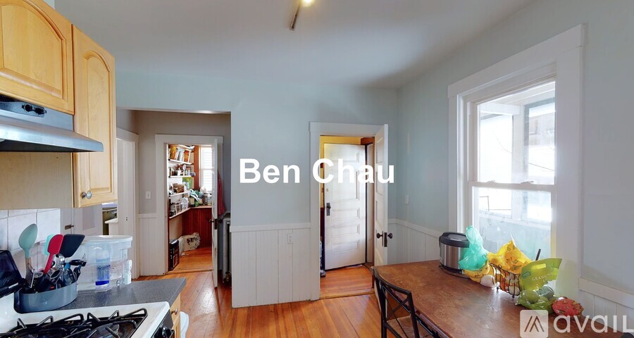 A kitchen with a stove top oven and a dining table with chairs.
