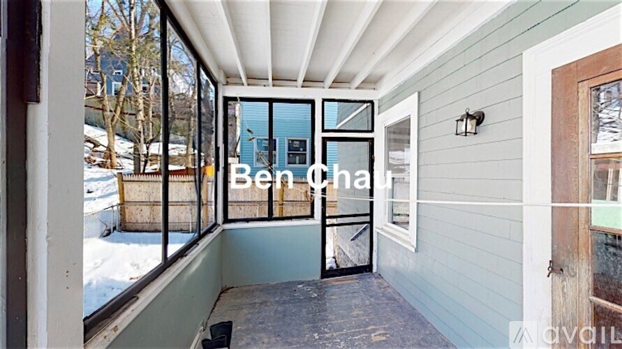 A balcony with a view of snow-covered ground and trees.