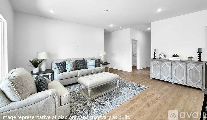 A living room with a grey sofa, a glass coffee table, and a wooden cabinet.