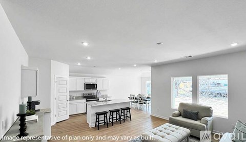A modern kitchen with white cabinets and a dining table with chairs.