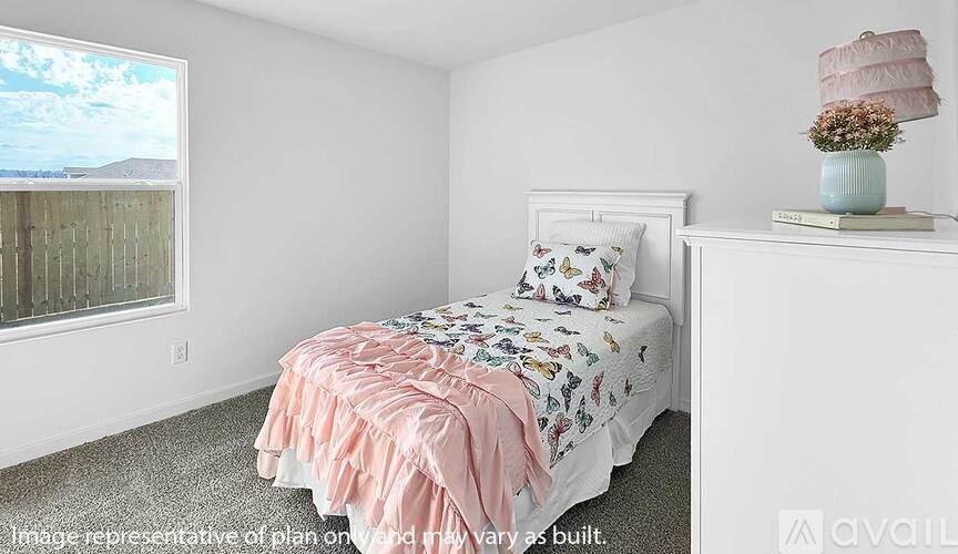 A bedroom with a bed, pillow, and a lamp on a nightstand.