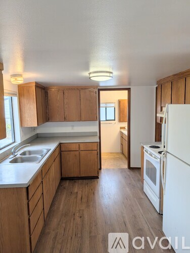 A kitchen with wooden cabinets and a white fridge.