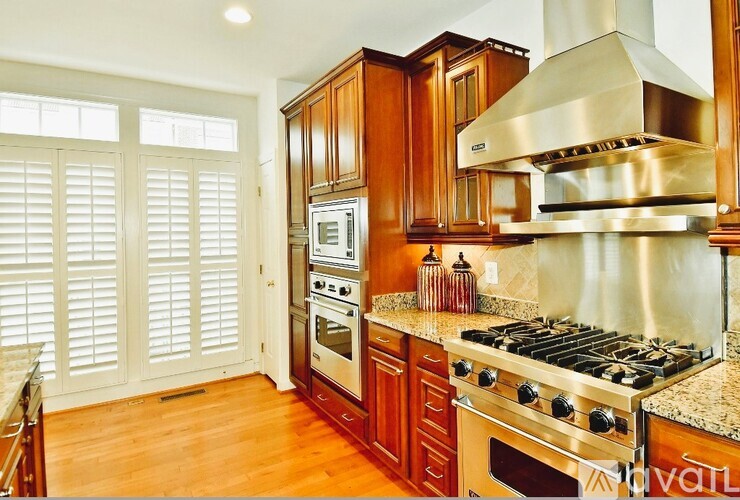 A kitchen with wooden cabinets and a stainless steel range hood.