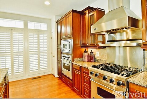 A kitchen with wooden cabinets and a stainless steel range hood.