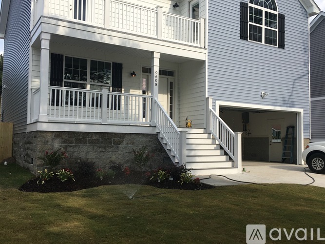 A house with a white porch and a stone wall.
