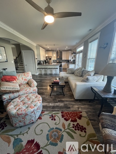 A living room with a sofa, armchair, and a rug with a floral pattern.