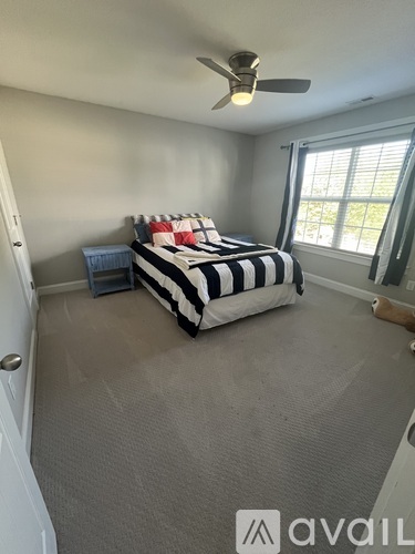 A bedroom with a bed and a ceiling fan.