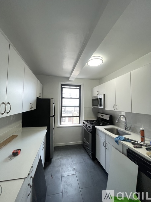 A kitchen with black appliances and white cabinets.