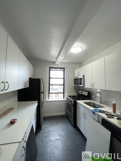 A kitchen with black appliances and white cabinets.