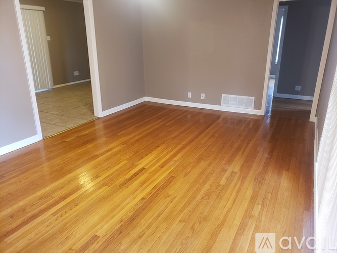 A room with wooden flooring and white walls.