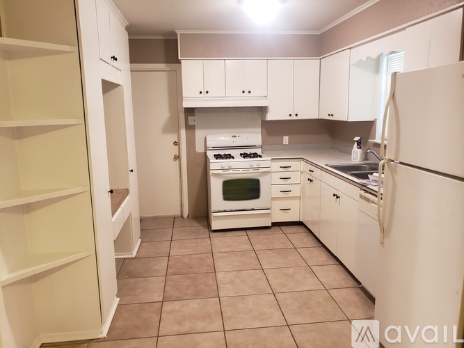 A kitchen with white appliances and cabinets.