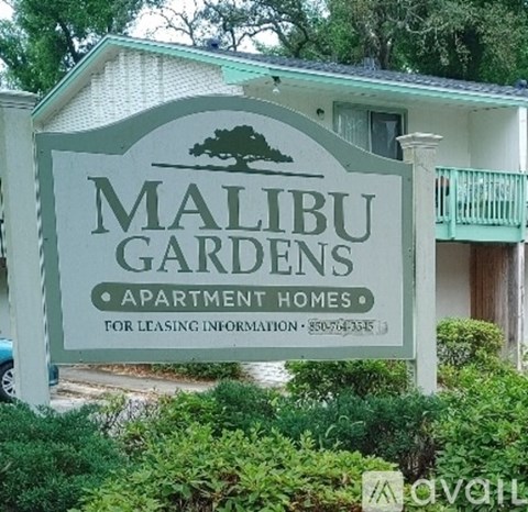 A sign for Malibu Gardens Apartment Homes with a phone number for leasing information.