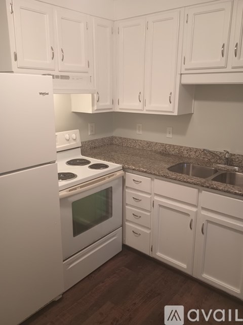 A kitchen with white cabinets and appliances.