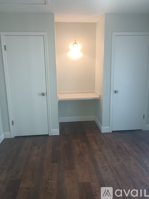 A room with white doors and a wooden floor.