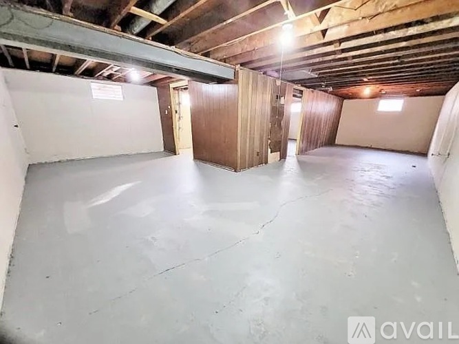 A spacious empty garage with a concrete floor and wooden walls.