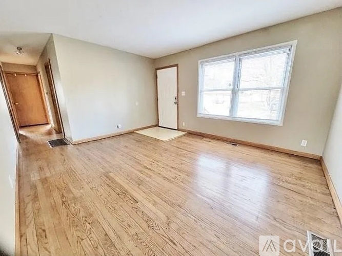 A room with wooden flooring and a window.