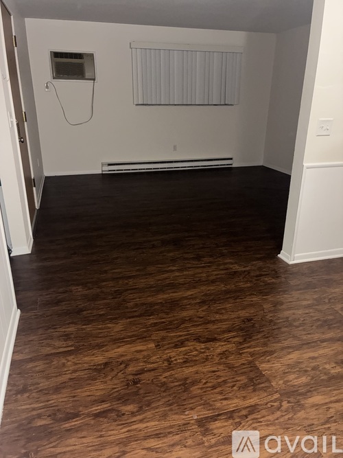 A room with wooden flooring and a radiator on the wall.