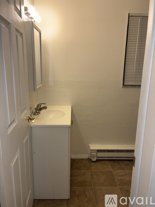 A small white sink in a small bathroom.