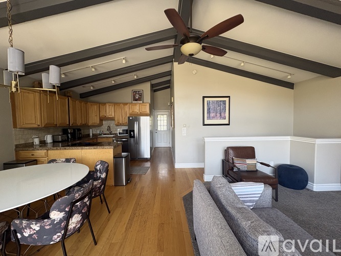 A kitchen with a dining table and chairs.