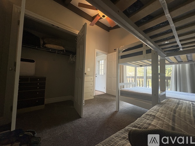 A bedroom with a bunk bed and a dresser.