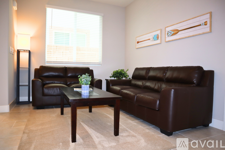 A living room with two brown leather couches and a coffee table.
