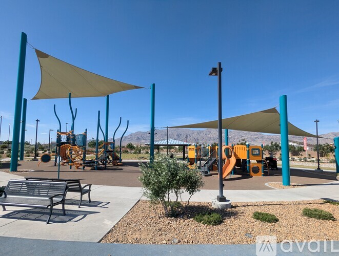 A playground with a yellow slide and a blue pole.
