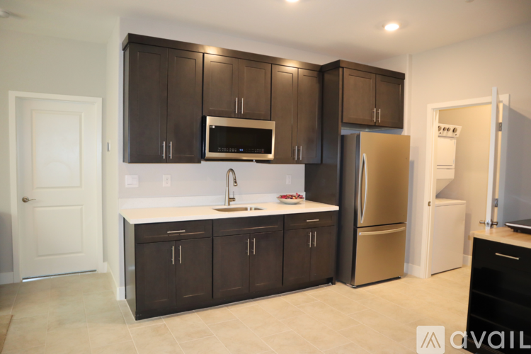A kitchen with dark brown cabinets and a white countertop.