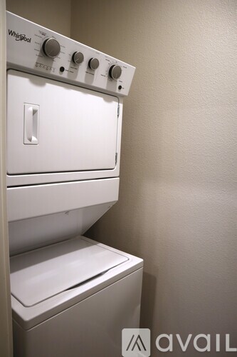 A white Whirlpool oven and dryer are installed in a wall.