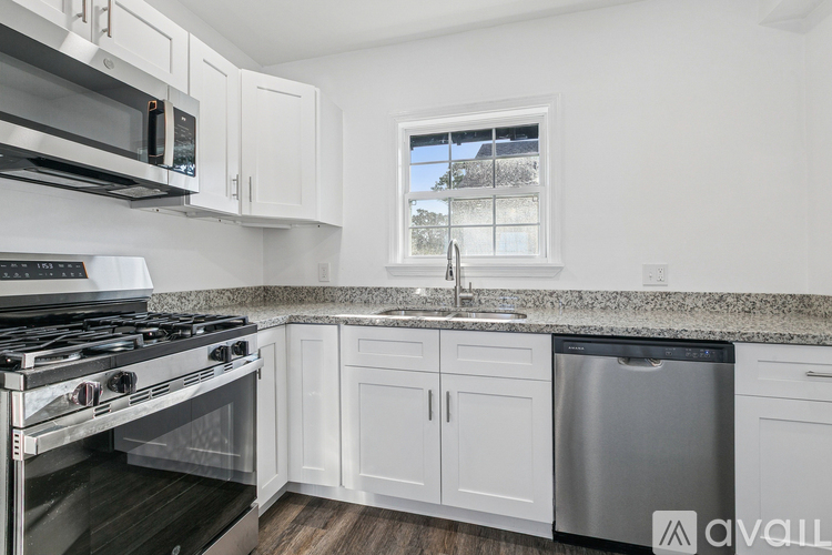 A kitchen with white cabinets and a granite countertop.
