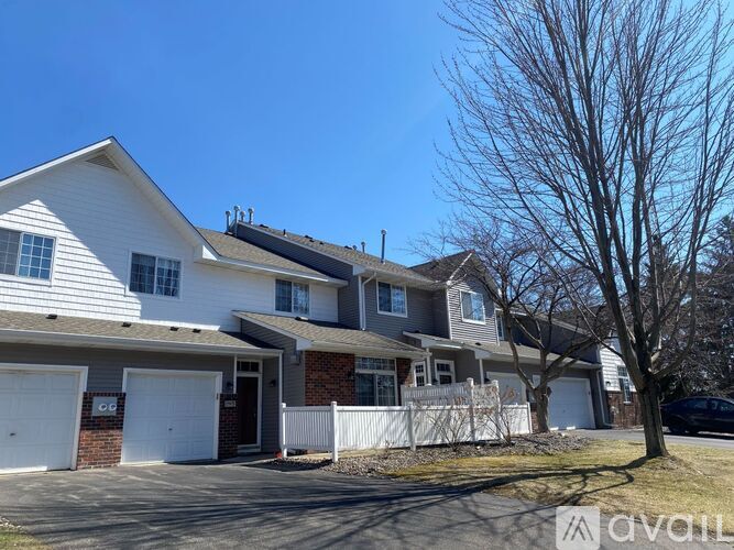 A two-story house with a white garage door is for sale.