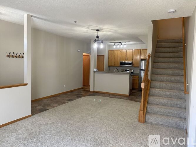 A spacious living room with a staircase leading to the upper floor.