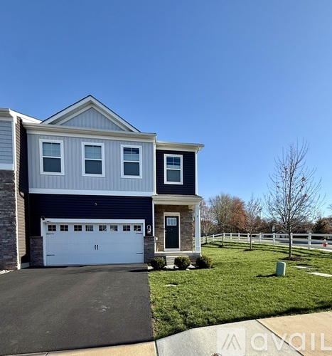 A two-story house with a garage and a driveway.