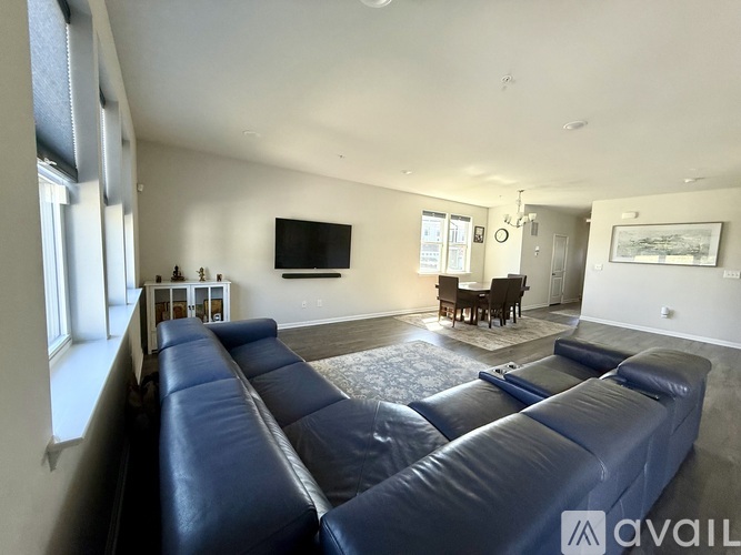 A living room with a blue couch and a television on the wall.