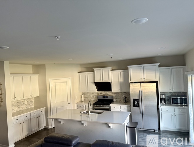 A kitchen with white cabinets and appliances.