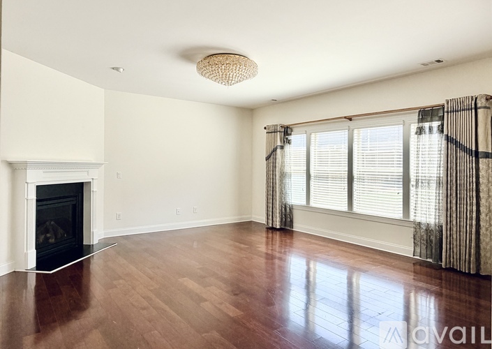 A living room with a fireplace and wood flooring.
