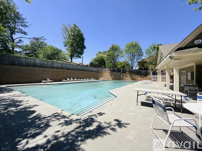 A pool with a table and chairs around it.