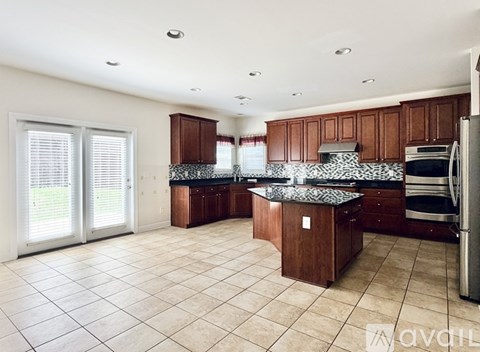 A kitchen with brown cabinets and a black and white tiled backsplash.
